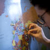 Student placing a pin on a world map