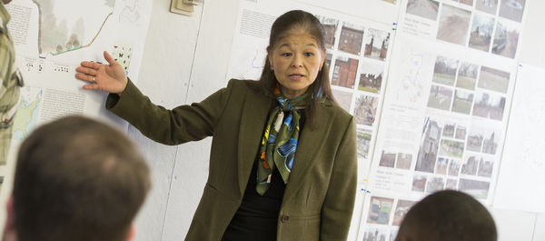 instructor pointing at board in front of students